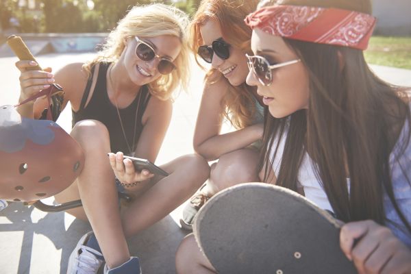 Group of Millennial women streaming a video on phone